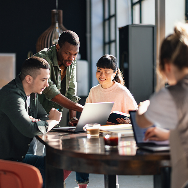 Young professionals collaborating in a bright, contemporary co-working environment, working on a full funnel digital marketing strategy for EducationDynamics' partners.